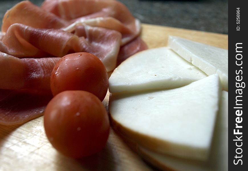 Platter of serrano ham, cherry tomatoes and smoked goat's cheese. Platter of serrano ham, cherry tomatoes and smoked goat's cheese
