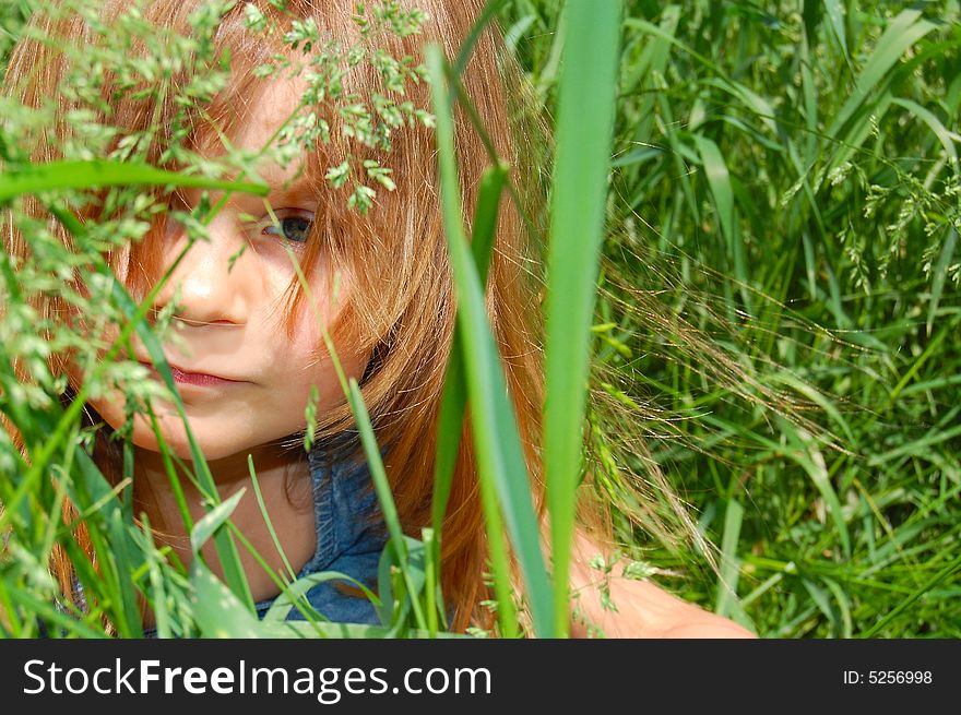 Portrait of a little sitting in grass little girl. Portrait of a little sitting in grass little girl