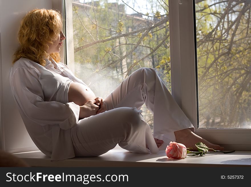Pregnant woman relaxing in the rays of sun. Pregnant woman relaxing in the rays of sun