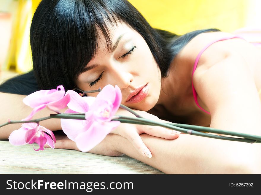 Beautiful asian girl with orchid. Low DOF, focus on eyes