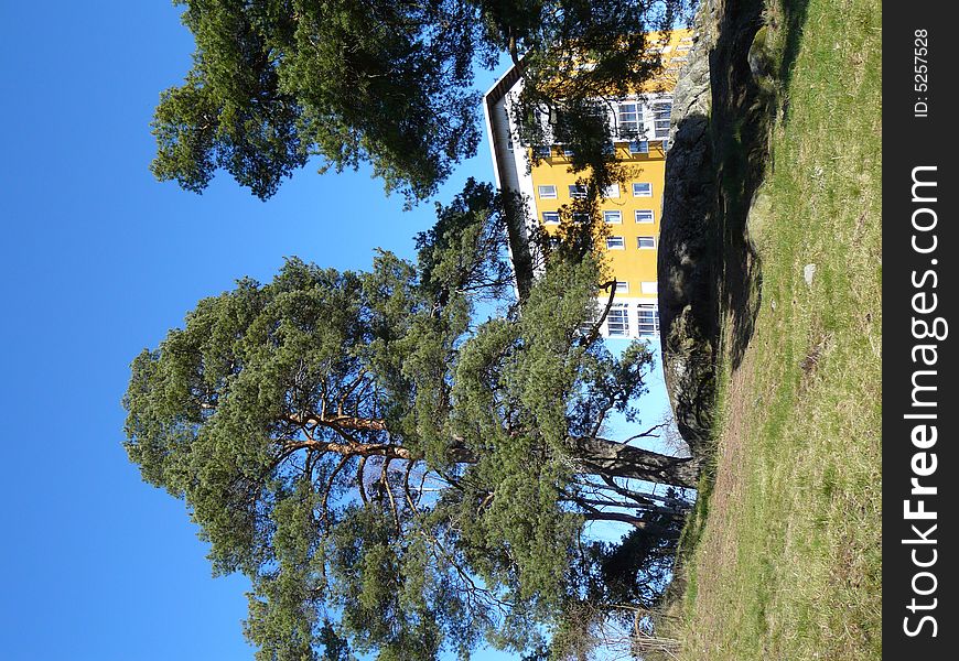 A yellow apartmenthouse behind a hill. A yellow apartmenthouse behind a hill.