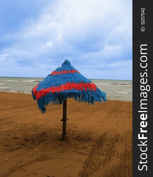 Coloured and isolated sea umbrella on brown sand taken during autumn. Coloured and isolated sea umbrella on brown sand taken during autumn