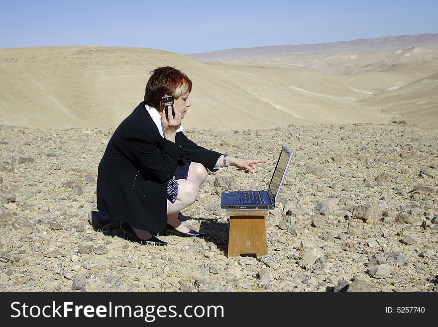 Young woman working with laptop in Judean desert. Young woman working with laptop in Judean desert
