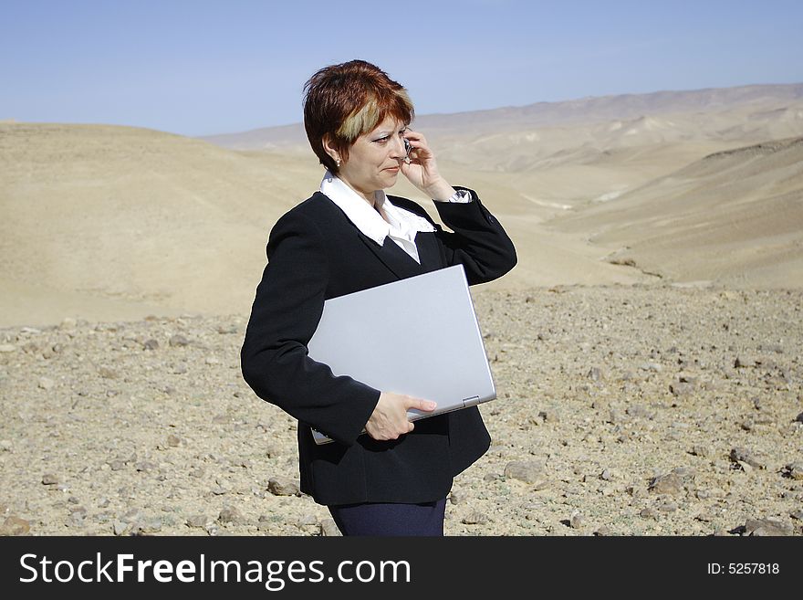 Young woman working with laptop in Judean desert. Young woman working with laptop in Judean desert