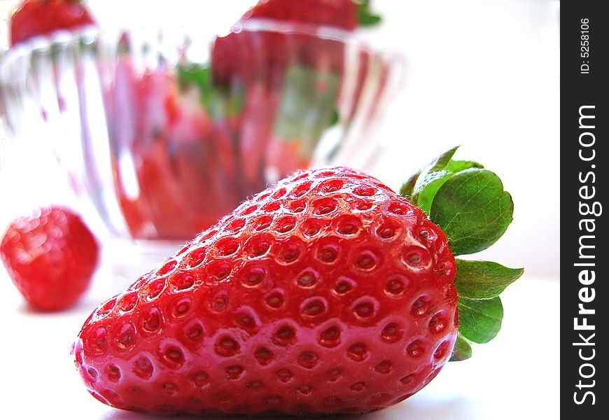 A strawberry with other strawberries in the white background