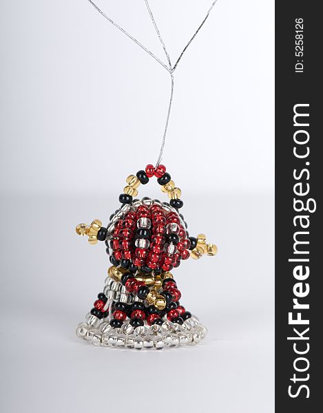 A figure made from chicken wire and beads featuring a round face and hands and with a skirt. A figure made from chicken wire and beads featuring a round face and hands and with a skirt