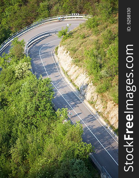 Steep road with serpentines with cyclist, Italy. Steep road with serpentines with cyclist, Italy