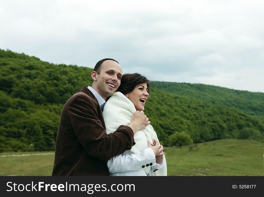 Young happy couple holding tight smiling outdoors