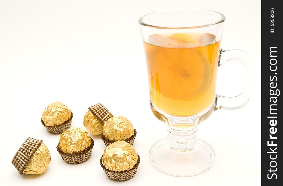 Tea with a lemon in glass chake and candies.