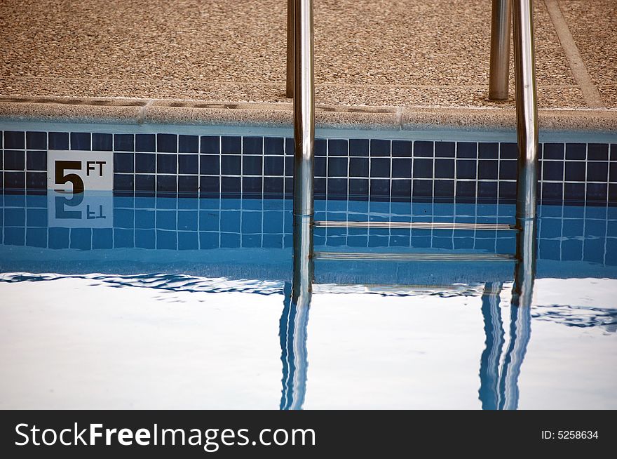 Ladder and sign at the deep end of a swimming pool.