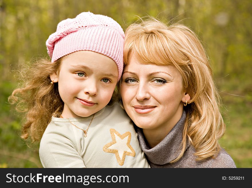 The beautiful little girl in a pink cap with smiling mum with light hair. The beautiful little girl in a pink cap with smiling mum with light hair