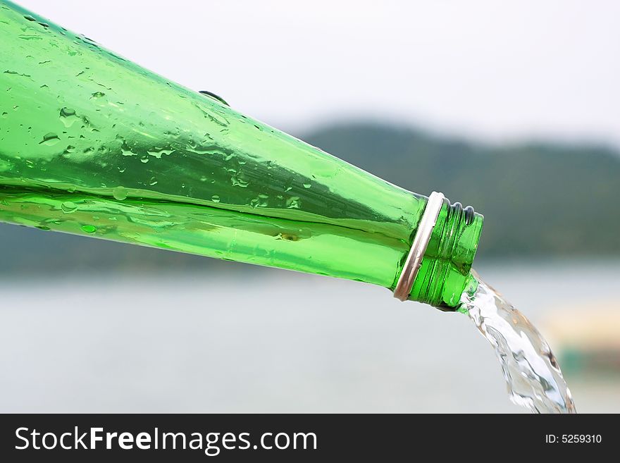 Water flowing out from a green bottle. Water flowing out from a green bottle.