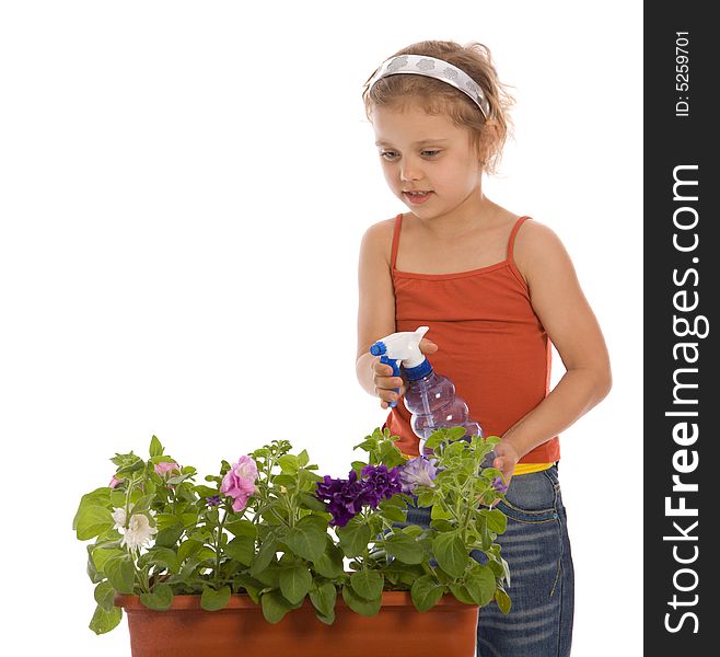 Young girl watering a flower in flowerpot