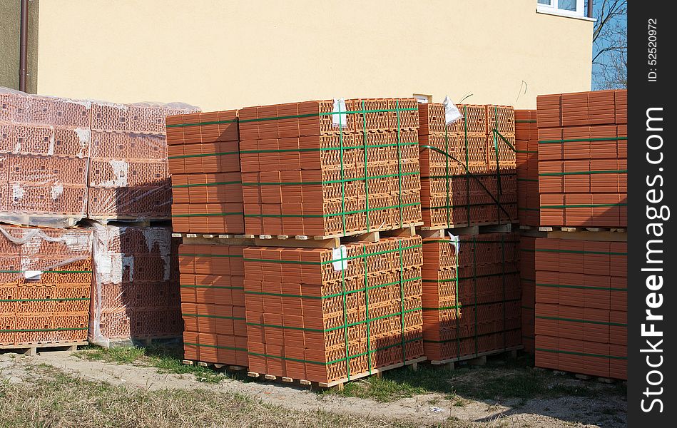 Stacks of red bricks for the construction on sunny spring day outside. Stacks of red bricks for the construction on sunny spring day outside
