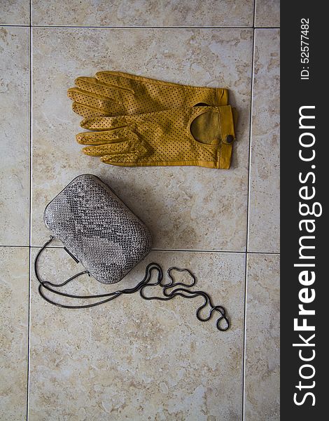 Yellow gloves and clutch on ceramic background. Yellow gloves and clutch on ceramic background