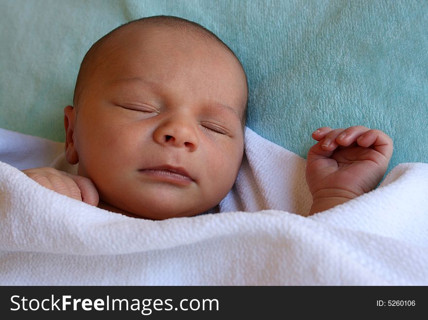 Week old baby boy on a blue blanket early in the morning. Week old baby boy on a blue blanket early in the morning