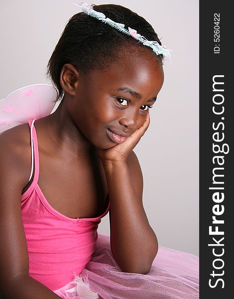 Young girl wearing a pink fairy costume with accessories