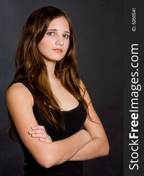 Young beautiful girl in a black vest on a black background. Young beautiful girl in a black vest on a black background