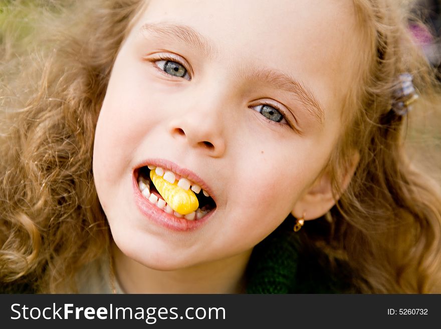 Portrait of the cheerful little girl with a candy. Portrait of the cheerful little girl with a candy