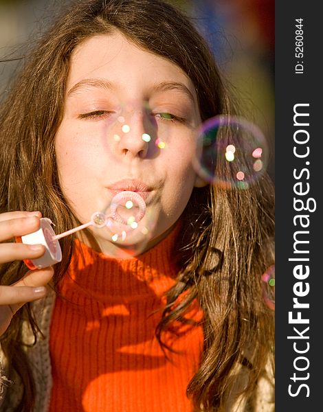 The young girl inflates soap bubbles