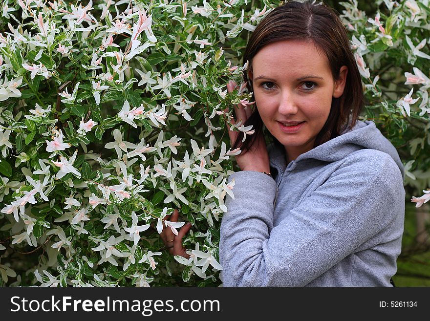 Young woman posing by the flowers. Young woman posing by the flowers