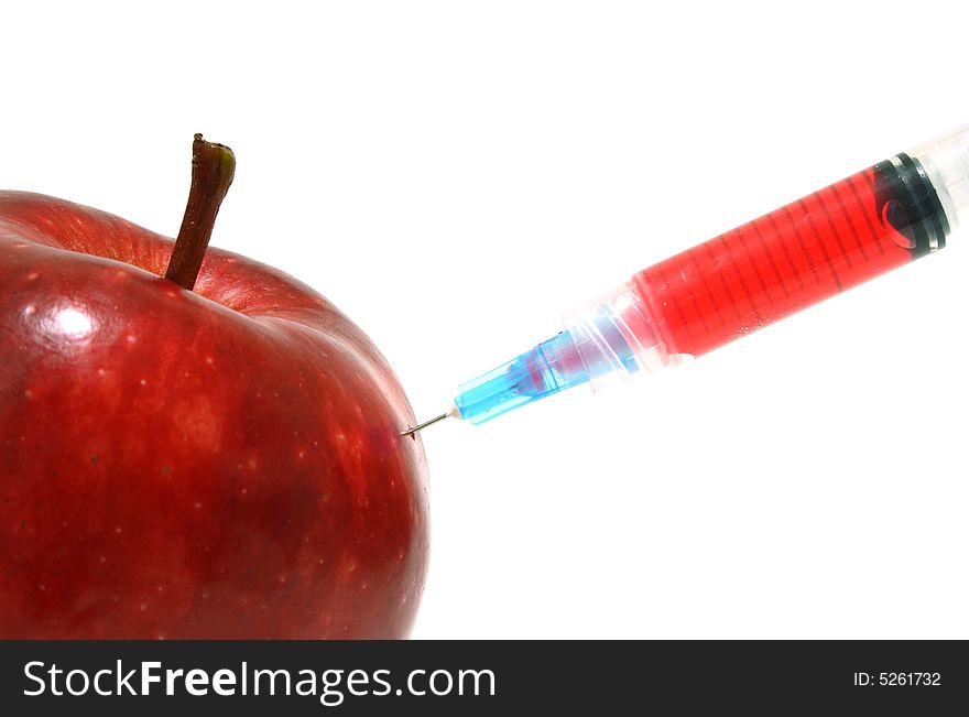 Syringe on a fresh and juicy red apple. Syringe on a fresh and juicy red apple
