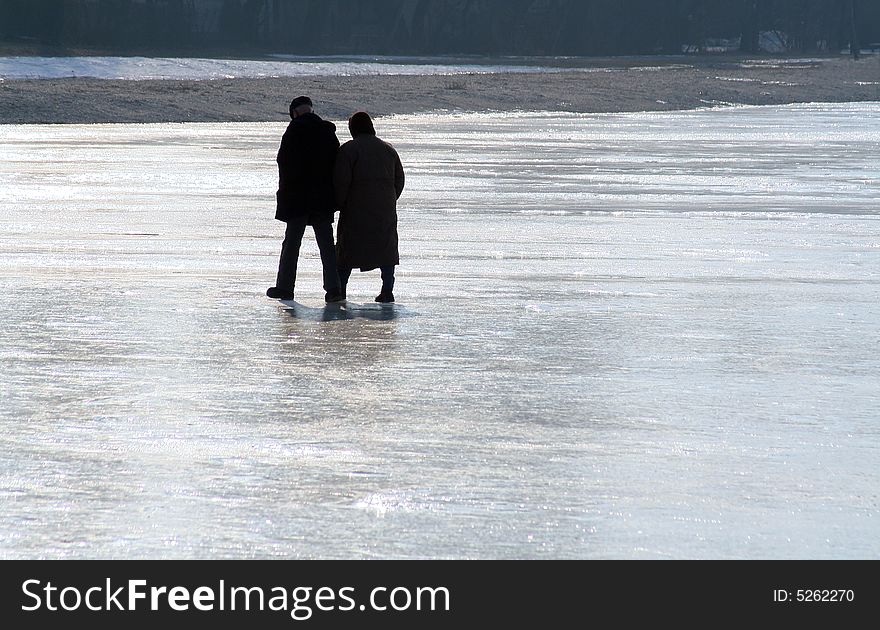 Two seniors having a walk on a frozen lake. Two seniors having a walk on a frozen lake