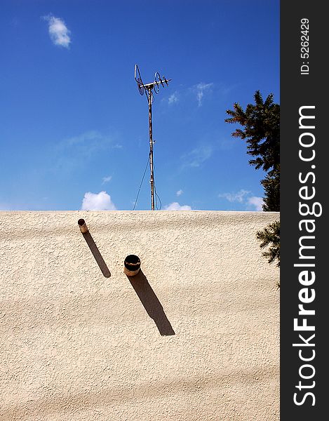 Home television antenna on a roof against  blue sky.