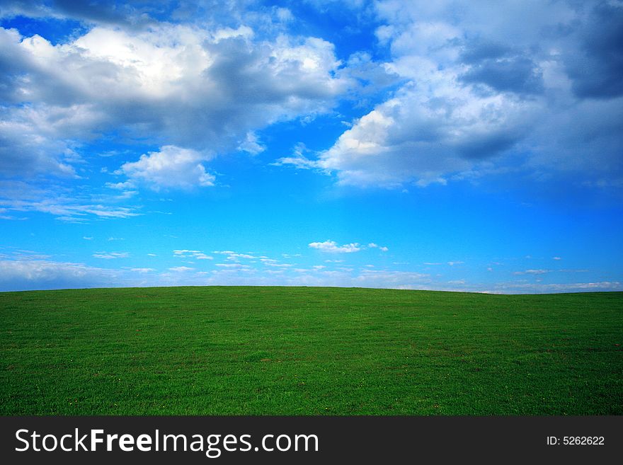 Green field and blue sky with thunder-clouds on it. Green field and blue sky with thunder-clouds on it