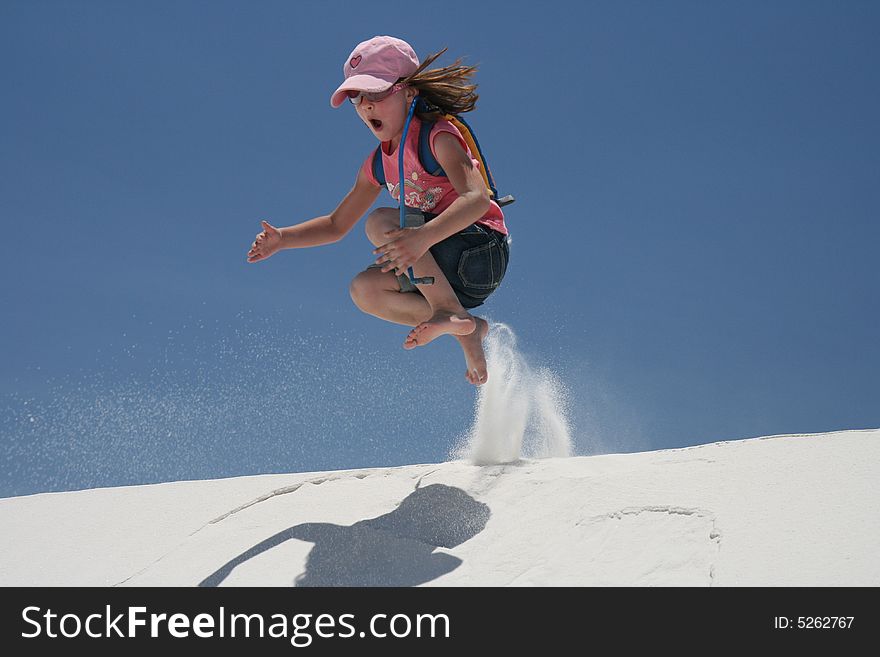 Young child jumping off a sand dune in the desert. Young child jumping off a sand dune in the desert