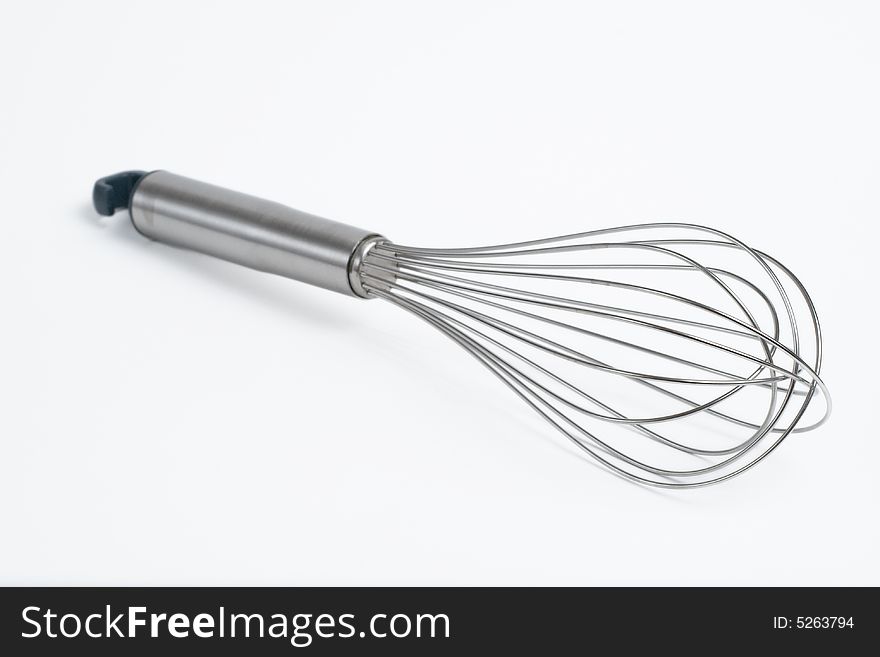 Stainless steel whisk, shallow DOF, on white