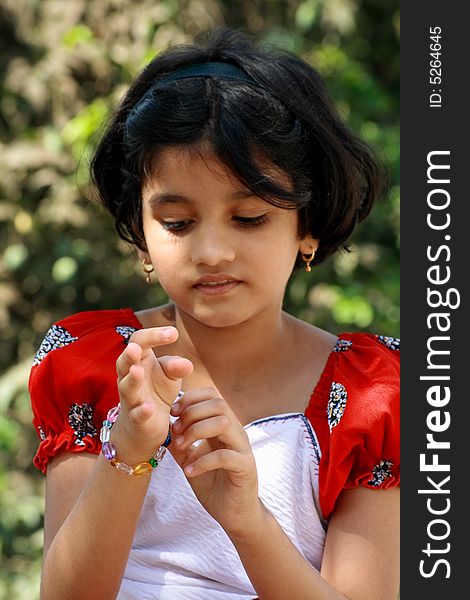 A beautiful Indian girl putting the bracelet in her hand.