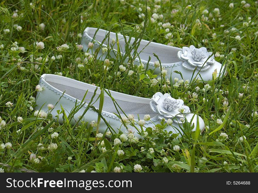 Ceremony white shoes laying on the grass