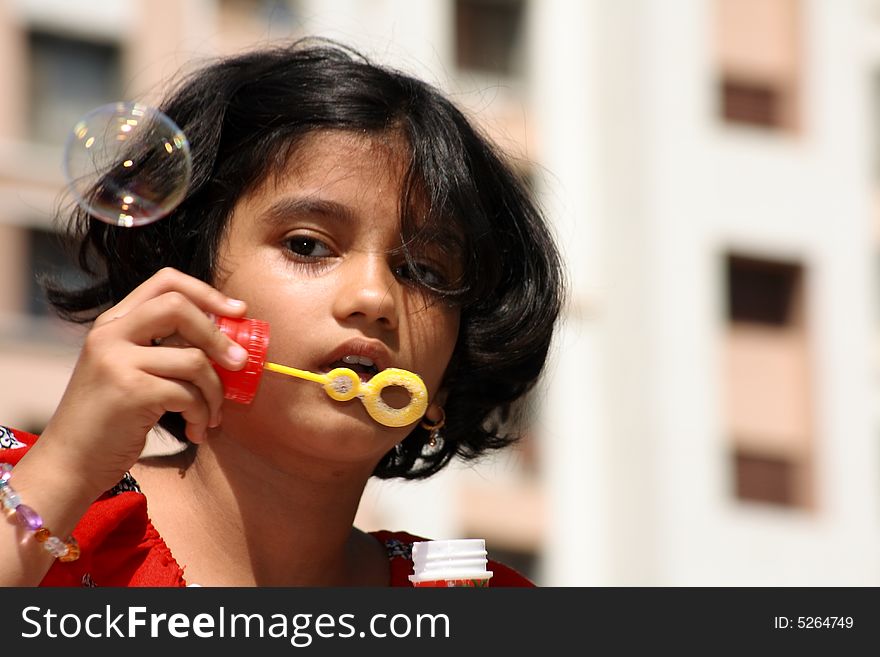 A fleeting expression of a girl while releasing the bubble. A fleeting expression of a girl while releasing the bubble.