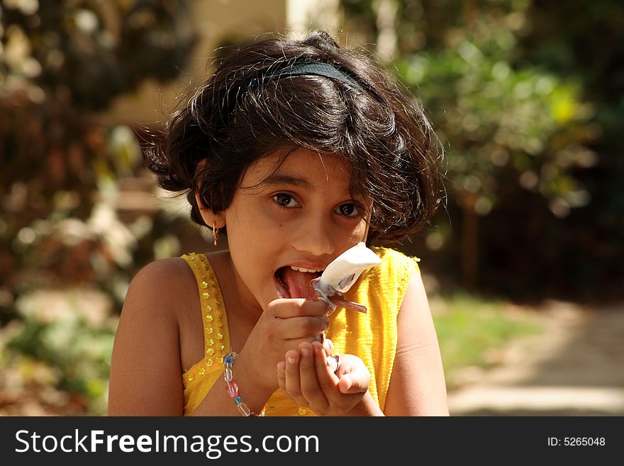 A girl licking the ice-cream candy.