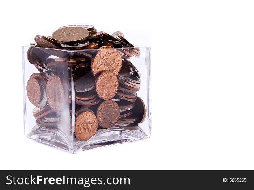A glass container filled to the top with British coins with space to the right for text. . A glass container filled to the top with British coins with space to the right for text. .