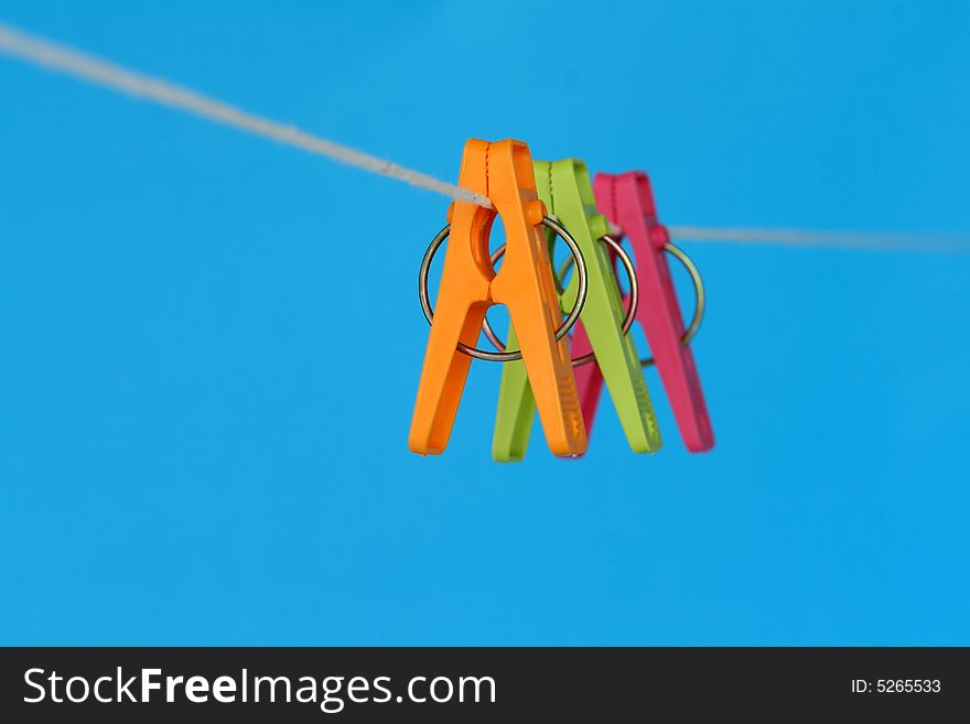 Three washing pegs hanging on a washing line.