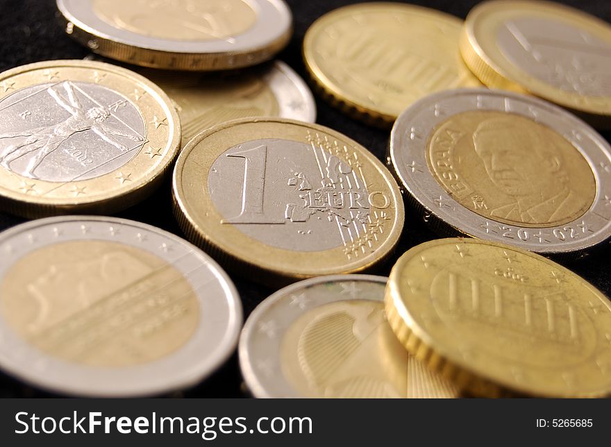 Several Euro coins of different countries and with different symbols.