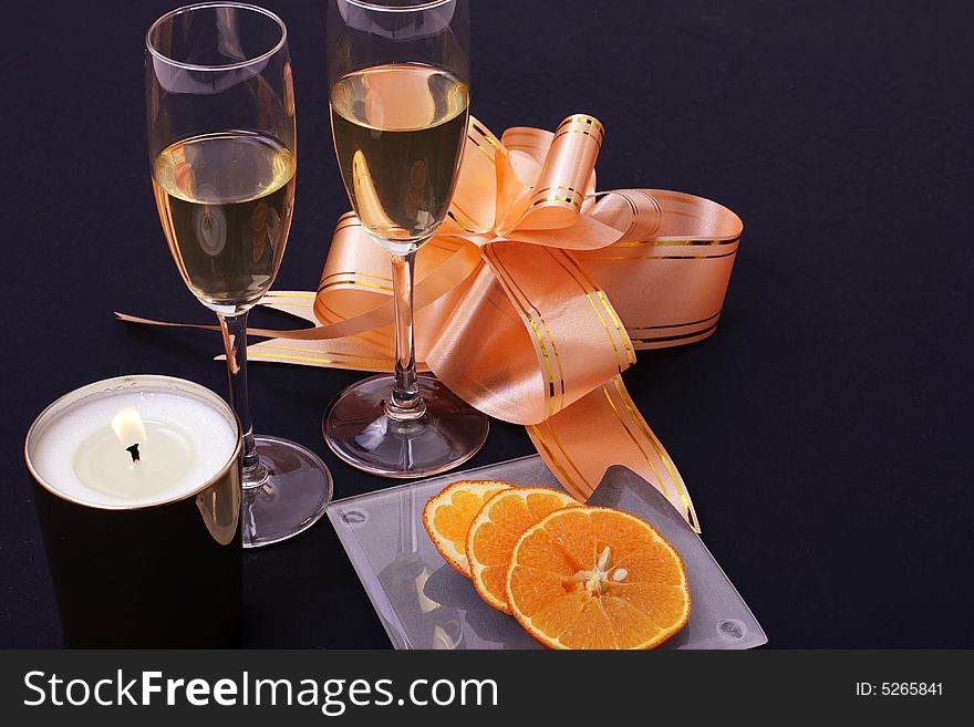 Wine, orange and candle on the black background. Wine, orange and candle on the black background