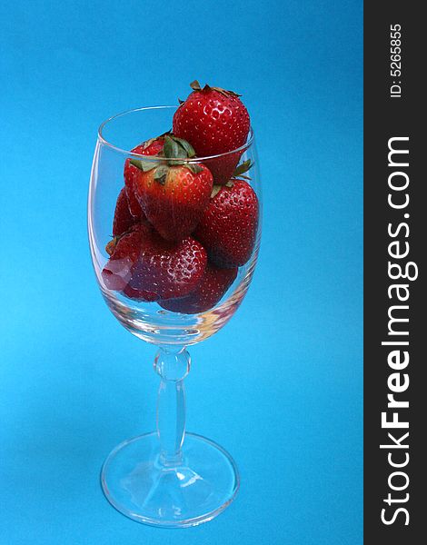 Strawberries in crystal glass with blue background. Strawberries in crystal glass with blue background