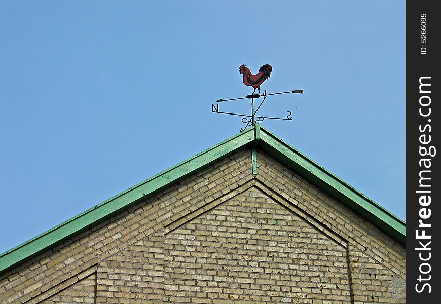 Old country weathercock vane on a tiled roof. Old country weathercock vane on a tiled roof