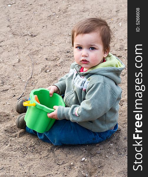 Thoughtful Boy In Green Dress With Bucket