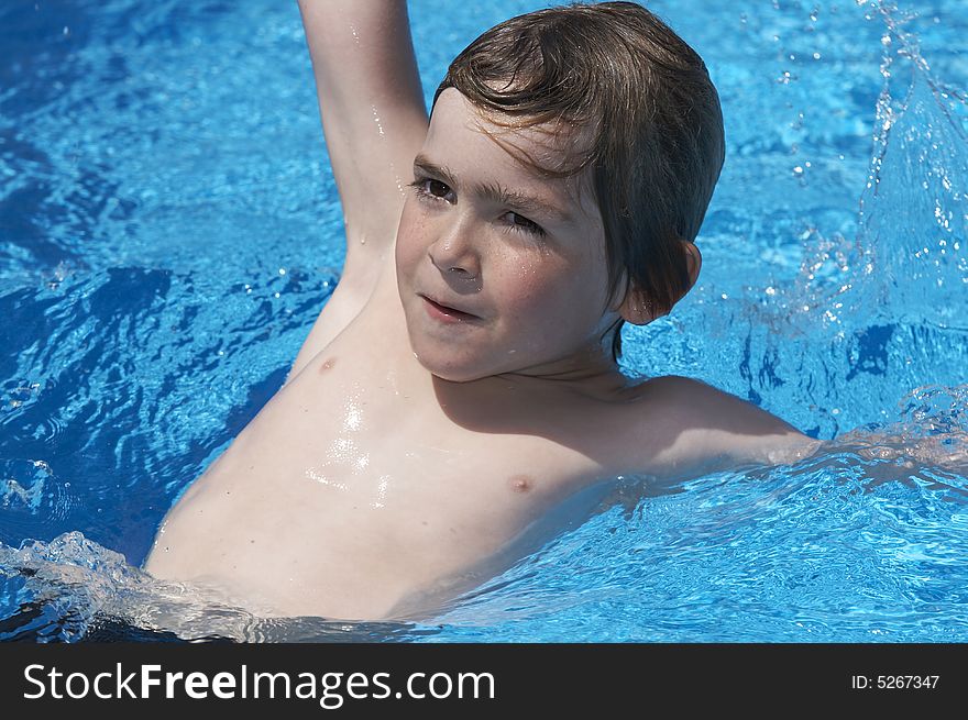 A young boy looking at camera in a pool. A young boy looking at camera in a pool