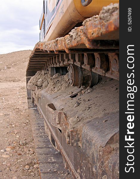 Dried mud and gears on a track belonging to a trackhoe on the job. Dried mud and gears on a track belonging to a trackhoe on the job.