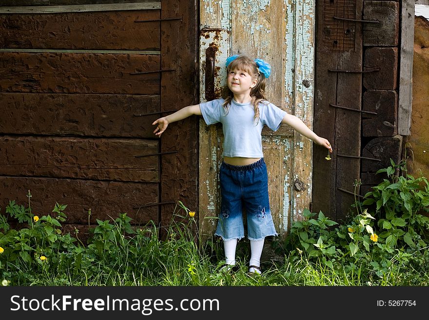 An image of girl with dandelion at old door. An image of girl with dandelion at old door