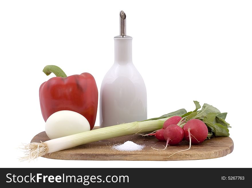 Still-life on a wooden hardboard with garden radish, paprika, onion and egg isolated on white.