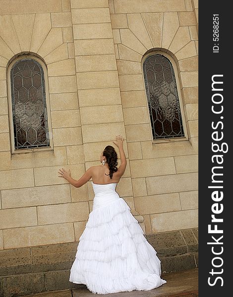 A bride standing next to a chapel. A bride standing next to a chapel