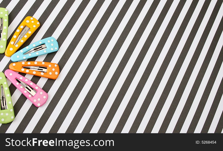 Brightly colored polka dot hair accessories on a striped background