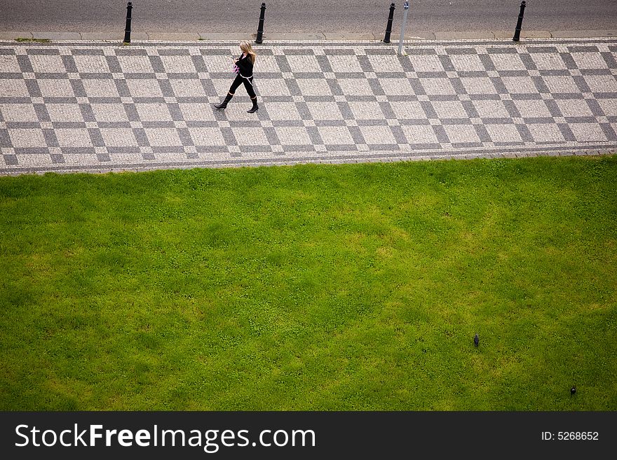 Young woman is walking on mosaic sidewalk. Young woman is walking on mosaic sidewalk.