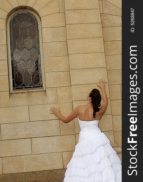 A bride standing next to a chapel. A bride standing next to a chapel